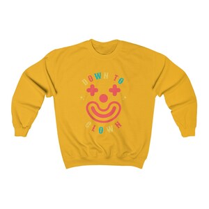 May include: Yellow sweatshirt with a colorful graphic of a clown face and the text "DOWN TO CLOWN".