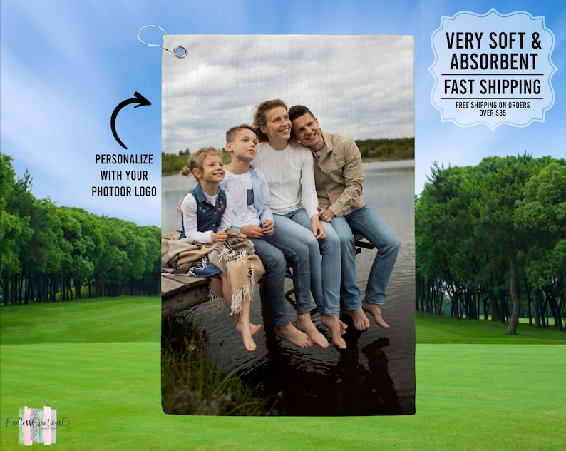 May include: A personalized golf towel with a photo of a family of four sitting on a dock by a lake. The towel is white with a blue border and has the text "VERY SOFT & ABSORBENT FAST SHIPPING FREE SHIPPING ON ORDERS OVER $35" printed on it.