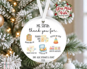 Op de afbeelding: Een rond wit ornament hangend aan een wit lint, met de tekst Ms. Sarah thank you for, voorzien van illustraties van een boekenplank, bordspel, stapelspeelgoed, knutselspullen, lunchtrommel en trein, ondertekend met Love- Allie, Brayden & Oliver 2026.