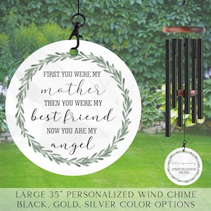 May include: A 35-inch personalized wind chime with a white circular disc featuring a green leafy wreath and the text "First you were my mother, then you were my best friend, now you are my angel". The chime is black with a silver personalized tag that reads "In loving memory Denise Wilkerson 1965-2025".