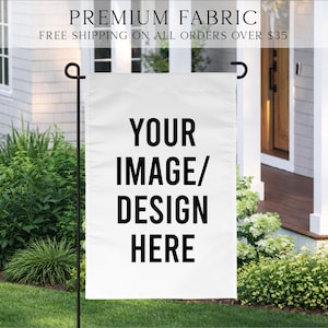 May include: A white garden flag with the text "YOUR IMAGE/ DESIGN HERE" in bold black letters. The flag is hanging on a black metal pole in a garden setting. The top of the flag reads "PREMIUM FABRIC".
