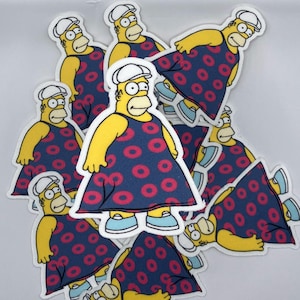 May include: A stack of yellow cartoon character iron-on patches. The character is wearing a blue dress with pink donut patterns. The character has a white hat and a yellow face.