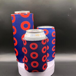 May include: Three blue and red can coolers with a donut pattern. The coolers are made of neoprene and are designed to keep drinks cold.
