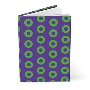 May include: A hardcover book with a purple cover featuring a repeating pattern of bright green circles. The book is slightly open, revealing white pages inside. The design is consistent across the front cover and the spine of the book.