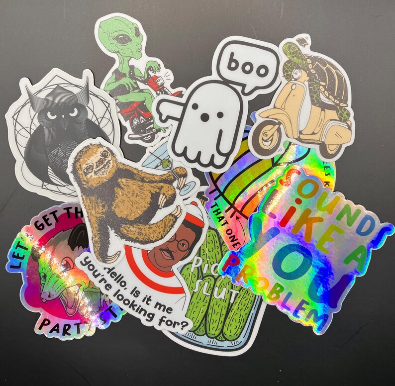 May include: A collection of colorful stickers featuring various designs, including a ghost, a sloth, a scooter, a pickle jar, and a holographic sticker that says "Sounds like a you problem".