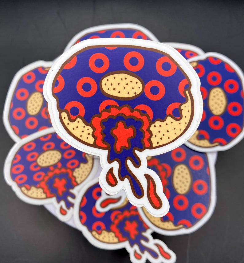 May include: A stack of blue and red donut stickers with white frosting and red and blue dripping icing. The donuts have a pattern of red rings on a blue background.