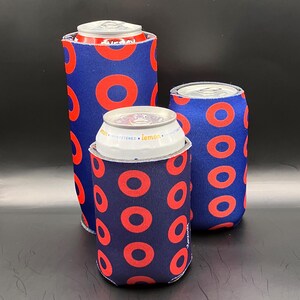 May include: Three blue and red can coolers with a donut pattern. The coolers are made of neoprene and are designed to keep drinks cold.