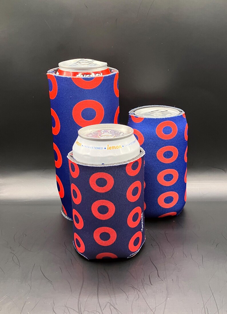 May include: Three blue and red can coolers with a donut pattern. The coolers are made of neoprene and are designed to keep drinks cold.