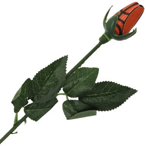 May include: A single orange and black basketball-shaped rose with green leaves and stem.