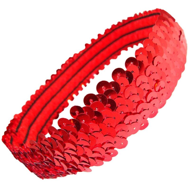 May include: A red sequin headband. The headband is made of small, shiny, circular sequins. The sequins are attached to a red elastic band. The headband is designed to be worn around the head. The sequins are closely packed together, creating a shimmering effect.