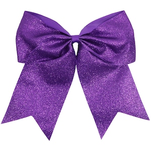 May include: A large, vibrant purple bow with a glittery finish. The bow features a classic design with two long, pointed streamers and a central knot. The ribbon has a textured appearance, adding visual interest to the accessory.