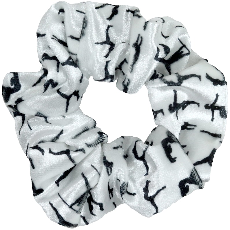 May include: White velvet scrunchie with a black silhouette pattern of people doing yoga poses.
