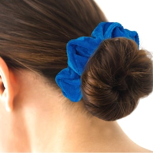 Puede incluir: Un scrunchie de terciopelo azul para el cabello.
