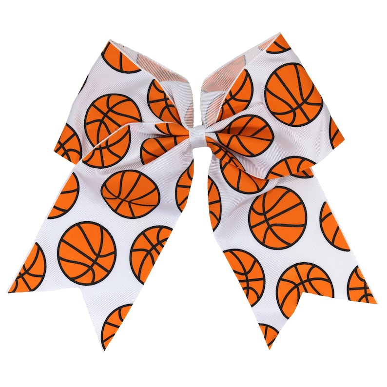 May include: White cheer bow with a basketball pattern. The bow is made of white ribbon with orange basketballs printed on it.