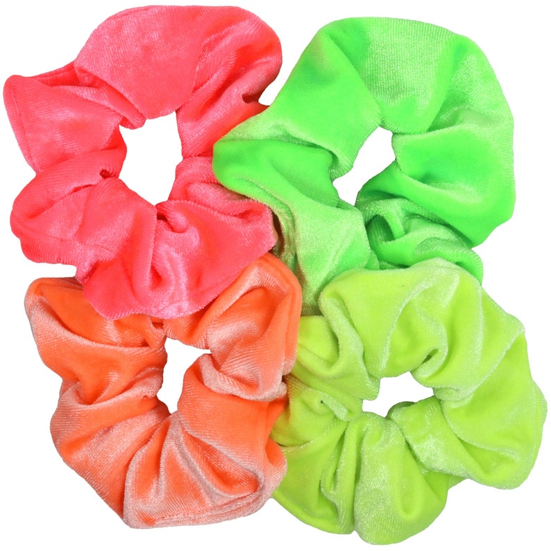 May include: Three neon-colored scrunchies in pink, orange, and green. The scrunchies are made of soft velvet and are perfect for adding a pop of color to any hairstyle.