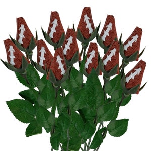 May include: A bouquet of artificial roses with brown football-shaped buds and green leaves.