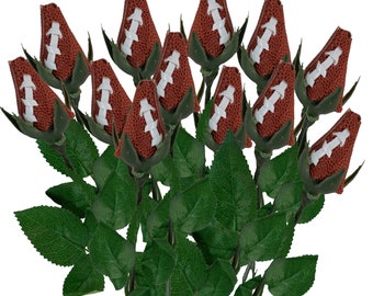 May include: A bouquet of artificial roses with brown football-shaped buds and green leaves.