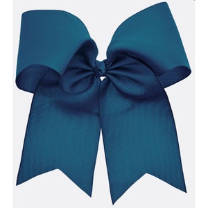 May include: A large teal blue hair bow with a double loop and two long tails.