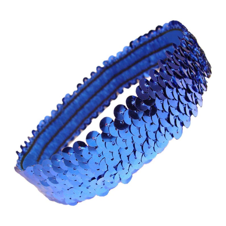 May include: A blue sequin headband. The headband is made of a stretchy blue fabric base, covered with rows of shiny, round blue sequins. The sequins are closely packed together, creating a shimmering effect. The headband is designed to be worn around the head.