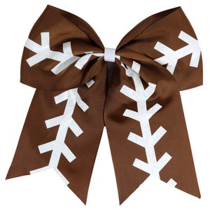 May include: A brown hair bow with white football stitching. The bow is made of a shiny, textured fabric.
