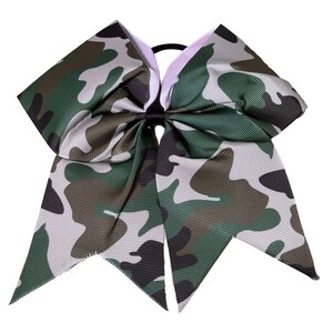 May include: A large green, brown, and white camouflage cheer bow with a black elastic hair tie.