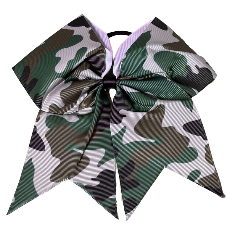 May include: A large green, brown, and white camouflage cheer bow with a black elastic hair tie.
