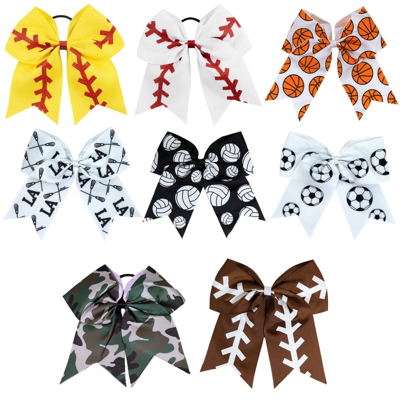 May include: Set of nine cheer bows with various sports themes. The bows are white with different colored and patterned designs, including baseball, basketball, soccer, volleyball, lacrosse, and camouflage.