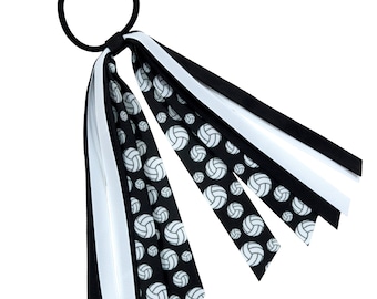 May include: Black and white volleyball hair tie with a black elastic band and multiple ribbons with a volleyball pattern.