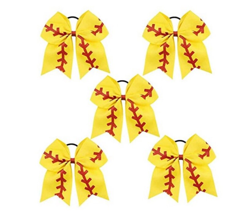 May include: Set of five yellow softball cheer bows with red stitching. Each bow has a black elastic hair tie.