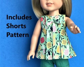 Op de afbeelding: Een pop die een groen en wit, mouwloos jurkje draagt met een roze strik en een groene broek. Het jurkje heeft een ananasprint. De pop heeft blond haar en blauwe ogen. De tekst "Includes Shorts Pattern" is zichtbaar in de afbeelding.