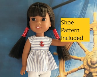 Op de afbeelding: Een pop die een blauw-wit gestreept jurkje draagt met een ankerontwerp, een witte broek en rood-witte schoenen. De pop heeft bruin haar en bruine ogen. De pop staat voor een houten scheepsrad. "Schoenpatroon inbegrepen" staat in geel op een witte achtergrond.