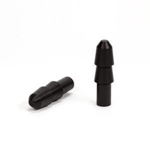 Puede incluir: Dos objetos cilíndricos negros con punta cónica y una serie de conos truncados apilados. Un objeto está tumbado horizontalmente, mientras que el otro está de pie. Los objetos están sobre un fondo blanco liso.