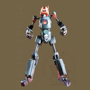 Può includere: Un giocattolo robot articolato e dettagliato, con un'estetica industriale e usurata. Il robot presenta una tavolozza di colori di verdi tenui, marroni e argento metallizzato. Il petto mostra un emblema di teschio e ossa incrociate.