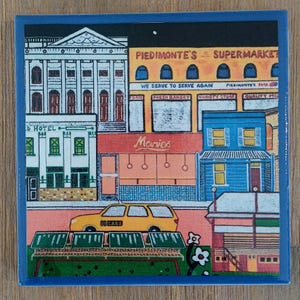 May include: A square ceramic tile featuring a colorful illustration of a city street scene. The image depicts a yellow taxi, a white hotel, and a yellow building labeled Piedmonte's Supermarket with text reading We Serve To Serve Again.