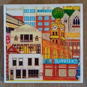 Peut inclure: Un carreau en c&eacute;ramique carr&eacute; pr&eacute;sentant une illustration color&eacute;e d'un paysage urbain. La sc&egrave;ne comprend le Cherry Tree Hotel, le Richmond Club Hotel et une tour d'horloge avec un d&ocirc;me vert. Le texte Rosella est visible sur un panneau bleu.
