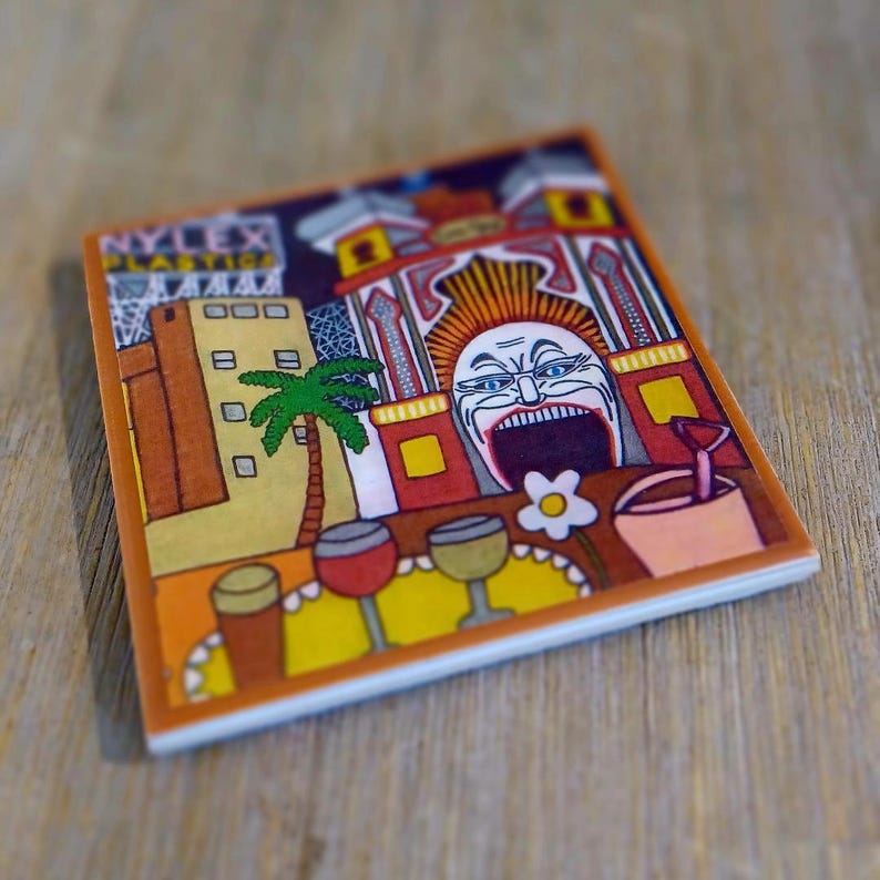 Puede incluir: Un posavasos cuadrado de cer&aacute;mica con una colorida ilustraci&oacute;n de un edificio con el texto NYLEX PLASTICS, una palmera, un gran rostro estilizado con la boca abierta y tres vasos sobre una mesa amarilla con una peque&ntilde;a flor blanca.