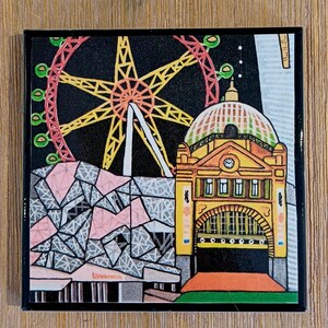Puede incluir: Un azulejo decorativo cuadrado con una colorida ilustraci&oacute;n de un edificio amarillo con c&uacute;pula y reloj, una gran noria roja y amarilla sobre un cielo negro, y una estructura geom&eacute;trica con patrones triangulares rosas y grises.