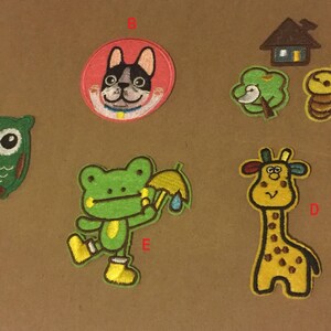 Op de afbeelding: Een set van tien geborduurde strijk-op patches met verschillende cartoondieren, waaronder een kikker, een giraffe, een uil, een hond en een bij. De patches zijn kleurrijk en fantasierijk, perfect om kleding, tassen of andere stoffen items een vleugje persoonlijkheid te geven.