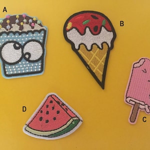 Puede incluir: Cuatro parches bordados para planchar que representan una magdalena con ojos saltones, un cono de helado, una paleta de helado y una rebanada de sandía.