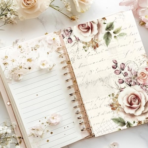 May include: Open spiral notebook with lined pages and a floral design. The cover features roses and leaves in shades of pink and cream, with script-like text. The notebook is open, revealing the lined pages and a decorative floral element.