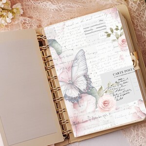 May include: Open beige planner with gold spiral binding, featuring a decorative insert with a butterfly, roses, and handwritten text. The insert has a vintage aesthetic with a soft color palette of pinks, greens, and beige.