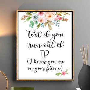 Puede incluir: Un cartel imprimible con flores de acuarela en rosa, azul y verde. El cartel dice "Envía un mensaje si te quedas sin papel higiénico (Sé que estás en tu teléfono)"