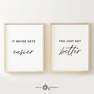 Puede incluir: Dos impresiones enmarcadas con citas motivacionales. La impresión de la izquierda dice "It never gets easier". La impresión de la derecha dice "You just get better".