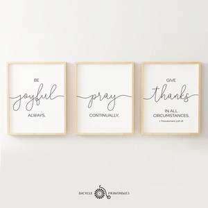 May include: Three framed prints with inspirational quotes. The first print says "Be joyful always". The second print says "Pray continually". The third print says "Give thanks in all circumstances. 1 Thessalonians 5:16-18".