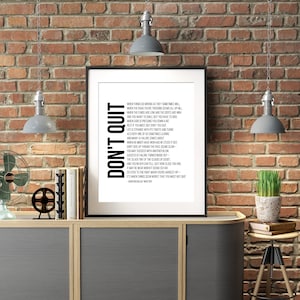 Pu&ograve; includere: Un poster di tipografia in bianco e nero con il testo "Don't Quit" e una citazione motivazionale di John Greenleaf Whittier. Il poster &egrave; incorniciato e appeso a un muro di mattoni.
