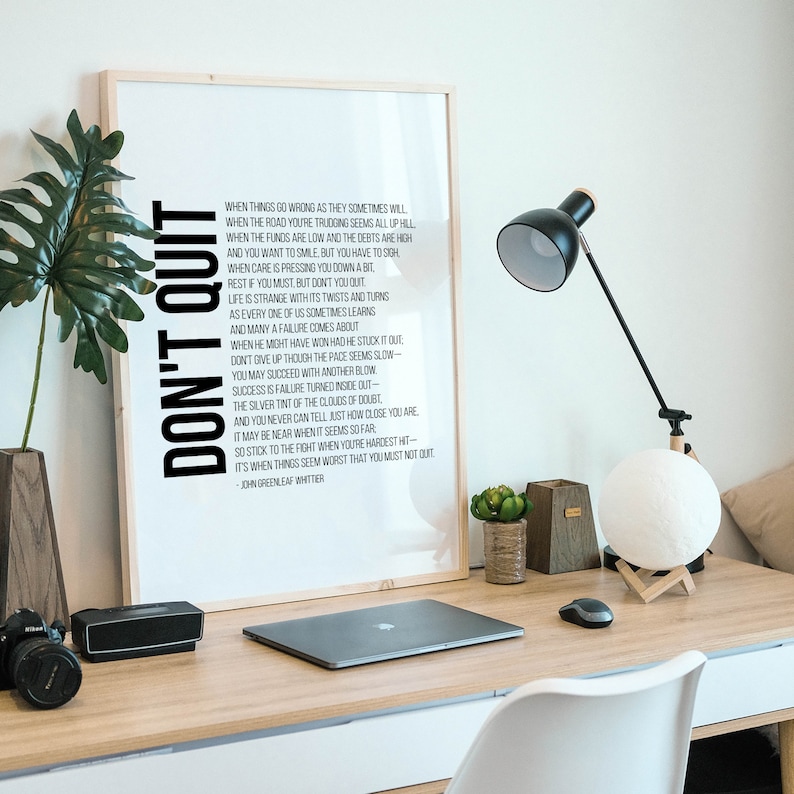 Pu&ograve; includere: Un poster di tipografia in bianco e nero con una citazione motivazionale, "Non mollare", di John Greenleaf Whittier. La citazione incoraggia la perseveranza e la resilienza di fronte alle sfide.