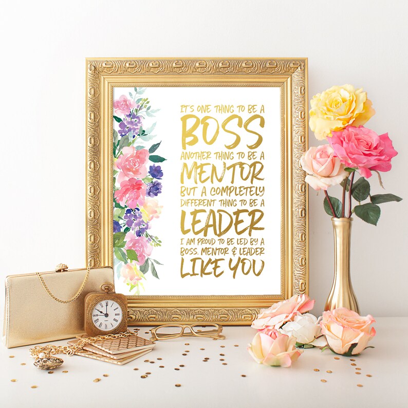 May include: A gold framed print with a white background and a floral design in the upper left corner. The text reads "It's one thing to be a boss, another thing to be a mentor, but a completely different thing to be a leader. I am proud to be led by a boss, mentor & leader like you."