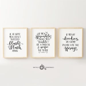 May include: Three framed bathroom signs with black calligraphy text on a white background. The signs read: "If at first you don't succeed flush flush again", "If you sprinkle while you tinkle be a sweetie & wipe the seatie", and "If your doodies be gray please use the spray".