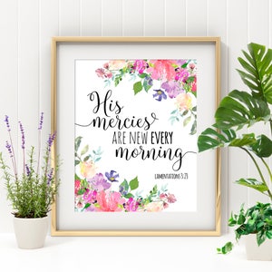 May include: A framed print with a watercolor floral design in shades of pink, purple, and green. The print features the text "His mercies are new every morning" with the scripture reference "Lamentations 3:23".