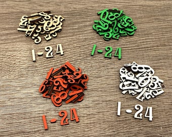 Könnte beinhalten: Vier Stapel aus Holznummern, jeder Stapel enthält die Zahlen von 1 bis 24. Die Stapel sind in einer Reihe angeordnet, wobei die Zahlen in jedem Stapel eine andere Farbe haben: beige, grün, orange und weiß.